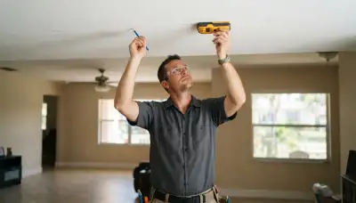 Fort Lauderdale electrician uses a stud finder to plan ceiling lighting fixture placement