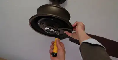 Electrician installing ceiling fan mounting bracket and fixture in Fort Lauderdale, FL