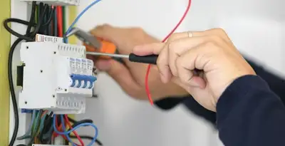 Electrician installing and adjusting circuit breakers in an electrical panel in Fort Lauderdale, FL