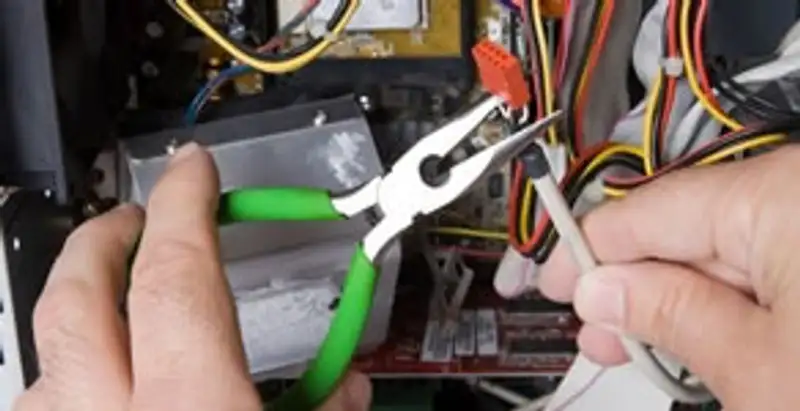 Licensed electrical contractor performing electrical repair with tools in Pembroke Pines, FL