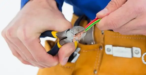 licensed electrician securing electrical wiring with professional tools during service work in Fort Lauderdale, FL