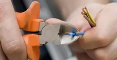 licensed electrician performing precise wire cutting and preparation during electrical service in Fort Lauderdale, FL