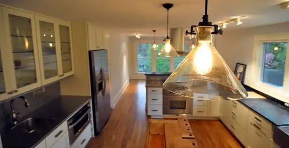 Residential electrician installing modern indoor light fixture in a home in Fort Lauderdale, FL